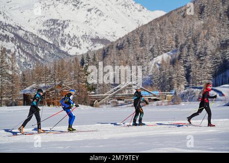 Eine Gruppe von Skilanglaufern an einem sonnigen Wintermorgen auf den Pisten von Pragelato in den Piemont Alpen. Pragelato, Italien - Dezember 2022 Stockfoto