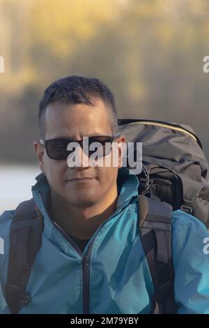 Porträt eines Reisenden am See im Herbst mit Sonnenbrille Stockfoto