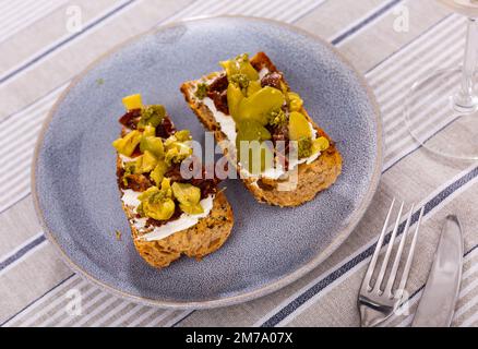 Sandwiches mit Frischkäse, sonnengetrockneten Tomaten, Oliven und Pesto Stockfoto