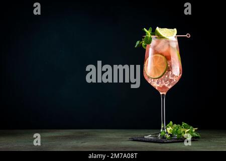 Französischer Orangenmuli, alkoholischer Cocktail mit Wodka, Limettensaft, Ingwerbier, Sirup, roter Orangensaft und Eiswürfel, garniert mit Minze. Dunkle Hintergrundebene Stockfoto