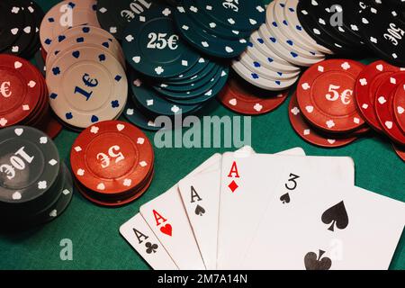 Vier Asse im Poker auf dem Spieltisch mit Chips in der Nähe des Casinos Stockfoto