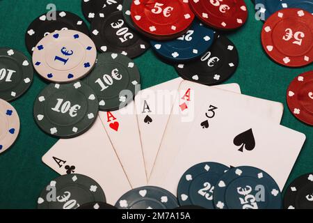 Vier von einer Art Asse Poker-Spiele-Chips. Die erfolgreiche Kombination von Karten auf dem grünen Tisch im Casino Stockfoto