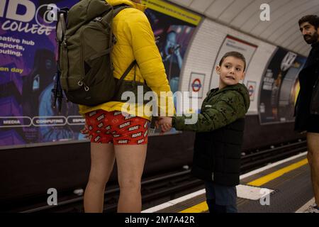 London, Großbritannien. 08. Januar 2023. Ein Teilnehmer der „U-Bahn-Tour ohne Hosen“ nimmt mit seinem Sohn an der Veranstaltung Teil. „No Housers Tube Ride“ kehrte nach London zurück, seit es 2020 aufgrund der COVID-Pandemie stattfand. Die Veranstaltung feiert in diesem Jahr ihr 10.-jähriges Jubiläum in London. Kredit: SOPA Images Limited/Alamy Live News Stockfoto