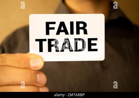 Geschäftskonzept. Auf den Rätseln liegen ein Taschenrechner und ein Stift, neben der Inschrift "FAIR TRADE". Stockfoto