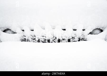 Der schneebedeckte Kühlergrill und die Scheinwerfer eines schwarzen Jeep Wranglers, der nach einem Schneesturm in den Adirondack Mountains, NY, USA, begraben wurde Stockfoto