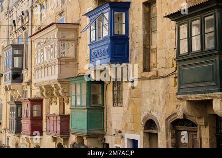 Traditionelle, farbenfrohe, geschlossene Holzbalkone, Gallariji genannt, auf der St. Paul Street - Valletta, Malta Stockfoto