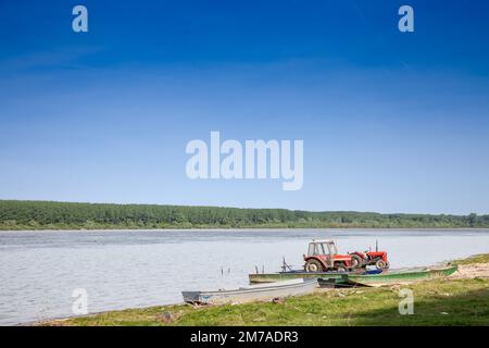 Panorama der Donau in Serbien mit Traktoren am Strand während eines sonnigen Sommernachmittages in Stari Slankamen, Serbien. Die Donau ist Europas sec Stockfoto