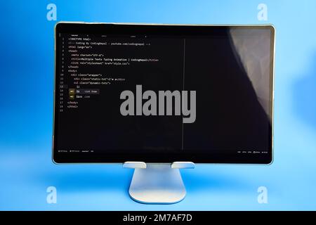 Schreibcode wird auf hellblauem Hintergrund des Monitors angezeigt Stockfoto