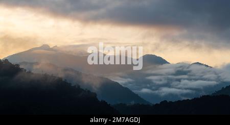 Panoramablick auf den Nebelwald Mindo bei Sonnenaufgang mit den Berggipfeln der Anden, Region Quito, Ecuador. Stockfoto