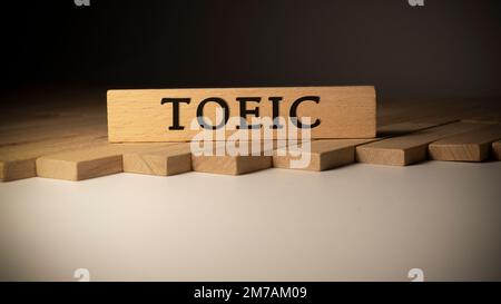 TOEIC-Text. Es wurde im Studio aufgenommen, auf einem Holzrahmen geschrieben. Weißer Hintergrund. Stockfoto