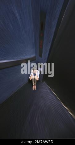 Gefangen von ihrer Phobie. Verzerrte Aufnahme einer jungen Frau, die in einem Aufzug gefangen ist. Stockfoto