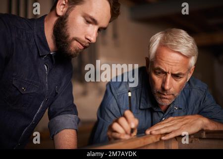 Ich lerne die Tricks des Gewerbes. Ein Vater zeigte seinem Sohn die Tricks des Baugewerbes. Stockfoto