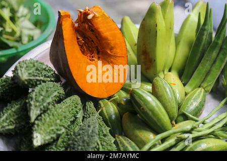 Eine Sammlung von bunten Gemüsesorten, die Kürbis, Bitter Gourd, Grüne Banane und Marienfinger enthalten, ist eine gute Nahrungsquelle für Kinder. Stockfoto