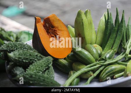 Eine Sammlung von bunten Gemüsesorten, die Kürbis, Bitter Gourd, Grüne Banane und Marienfinger enthalten, ist eine gute Nahrungsquelle für Kinder. Stockfoto