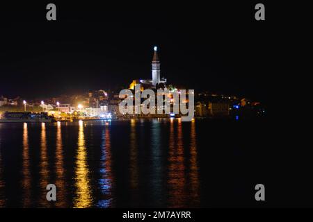Die Halbinsel Istrien mit Lichtern der Stadt Rovinj, die auf der Oberfläche des Meeres in Kroatien reflektieren Stockfoto