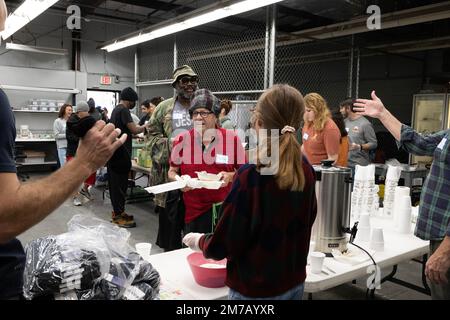 Tampa, Florida, USA. 31. Dezember 2022. Die Bewohner von Tampa Hope erhalten Frühstück und neue Socken von Freiwilligen aus dem Obdachlosenheim. (Kreditbild: © Robin Rayne/ZUMA Press Wire) Stockfoto