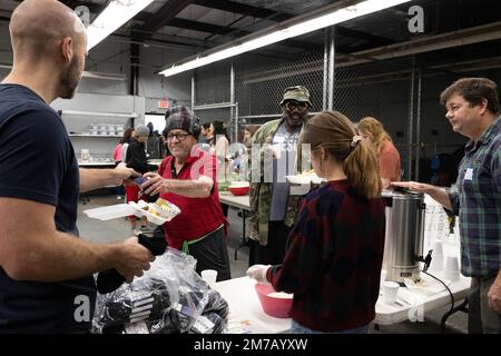 Tampa, Florida, USA. 31. Dezember 2022. Die Bewohner von Tampa Hope erhalten Frühstück und neue Socken von Freiwilligen aus dem Obdachlosenheim. (Kreditbild: © Robin Rayne/ZUMA Press Wire) Stockfoto