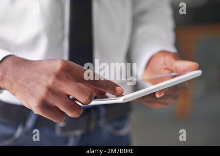 Technologie bringt Sie an die Spitze. Ein Mann, der sein digitales Tablet berührt. Stockfoto