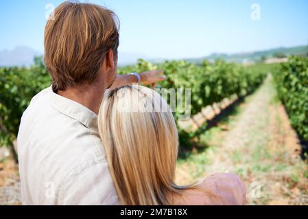Stolz auf den Weinberg der Familie. Rückansicht eines erwachsenen Paares, das einen Tag in den Weinbergen genießt. Stockfoto