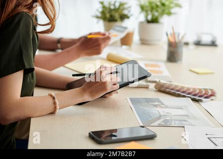 Ein Team von Innenarchitekten zeichnet Skizzen für neue Projekte auf einem Tablet-Computer Stockfoto