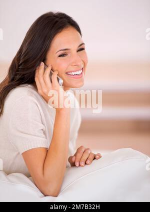 Es ist toll, deine Stimme zu hören. Eine wunderschöne junge Frau auf einer Couch. Stockfoto