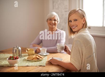 Ein liebevoller Besucher. Eine attraktive junge Frau besucht ihre oma zum Tee. Stockfoto