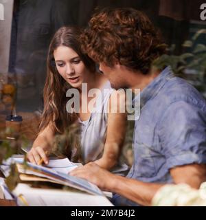 Also, müssen Sie dieses Kapitel noch einmal durchgehen? Zwei junge Studenten, die in einem Café studieren. Stockfoto