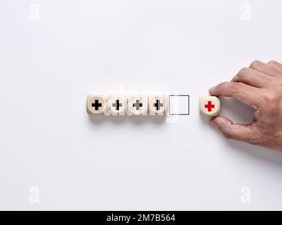 Wertschöpfungskonzept. Verbesserung oder Ergänzung von etwas, das mehr wert ist. Positives Denken oder persönliche Weiterentwicklung. Männliche Hand arrangiert das Holz Stockfoto