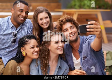 Mach dich über deine Nummer Eins lustig. Ein Foto von Studenten mit einem Handy auf dem Campus. Stockfoto