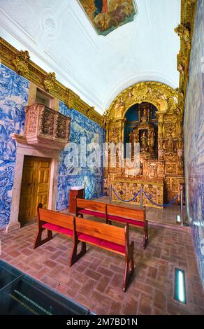 Innenansicht der kleinen Kapelle mit reich geschnitzten, goldenen Holzaltar und dem berühmten Azulejo, blauen Fliesenwänden. In der Ermida de Nossa Senhora da Conceic Stockfoto