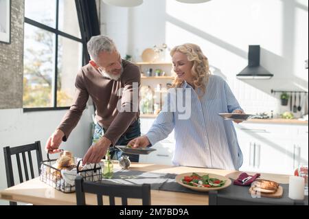 Mann und Frau bedienen den Tisch zum Abendessen Stockfoto