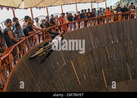 Mumbai, Indien. 08. Januar 2023. Ein Motorradfahrer im Maut ka Kuan (Brunnen des Todes) sammelt während der Erangal-Messe in Mumbai Geld vom Publikum. Die Messe ist auch bekannt als St. Bonaventure Festmahl. Es markiert die Taufe oder Namenszeremonie von Jesus Christus und ist wie ein jährliches Treffen der ostindischen Gemeinschaft. Die Leute kommen und beten in der St. Bonaventure Kirche, die sich am Strand befindet, posten, dass sie Vergnügungsfahrten am Strand genießen und dort Essen und essen. Kredit: SOPA Images Limited/Alamy Live News Stockfoto