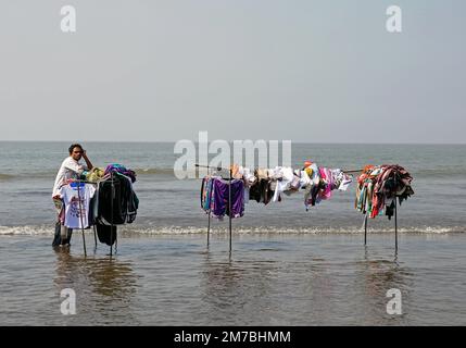 Mumbai, Indien. 13. Januar 2013. Ein Händler steht im knöcheltiefen Wasser des Arabischen Meeres, während er auf der Erangal Fair in Mumbai auf die Kunden wartet. Die Messe ist auch bekannt als St. Bonaventure Festmahl. Es markiert die Taufe oder Namenszeremonie von Jesus Christus und ist wie ein jährliches Treffen der ostindischen Gemeinschaft. Die Leute kommen und beten in der St. Bonaventure Kirche, die sich am Strand befindet, posten, dass sie Vergnügungsfahrten am Strand genießen und dort Essen und essen. (Foto: Ashish Vaishnav/SOPA Images/Sipa USA) Guthaben: SIPA USA/Alamy Live News Stockfoto