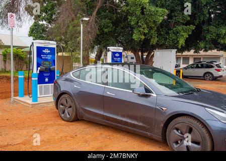 Ein Auto, das an einer Tritium NRMA-Batterieladestation für Elektrofahrzeuge (EV) auf einem Parkplatz in Nyngan im Westen von New South Wales, Australien, aufgeladen wird Stockfoto