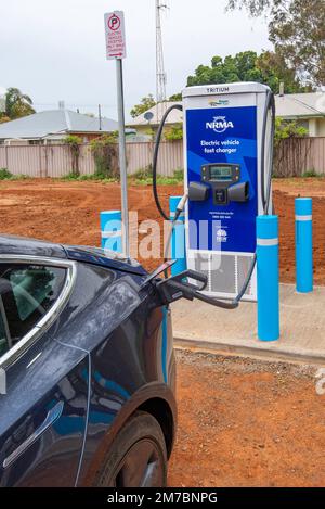 Ein Auto, das an einer Tritium NRMA-Batterieladestation für Elektrofahrzeuge (EV) auf einem Parkplatz in Nyngan im Westen von New South Wales, Australien, aufgeladen wird Stockfoto