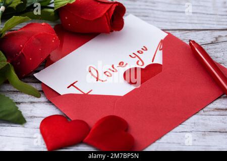 Herzförmige Boxen mit rosa und roten Herzen auf rotem Hintergrund Stockfoto