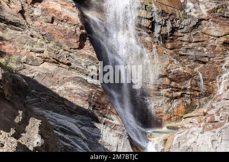 Kontrastreiche, helle Nahaufnahme des schäumenden Wassers des Lillaz-Wasserfalls (Cascate di Lillaz) über Karst-Granit-Stromschnellen. Aosta-Tal, Italien Stockfoto