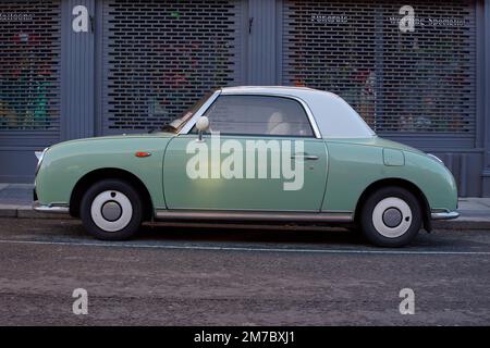 Seitenansicht des Nissan Figaro, der in einer Straße in Bray, Irland, parkt. Fahrzeug, das 1991 in Japan hergestellt wurde, mit smaragdgrüner Außenfarbe, die den Frühling symbolisiert. Stockfoto