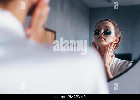 Die junge Frau kümmert sich um ihre Gesichtshaut Stockfoto