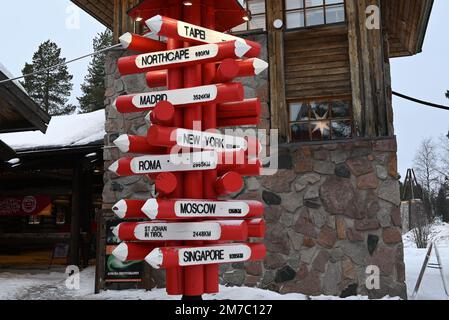 Einige Kilometer nördlich von Rovaniemi befindet sich das Dorf des Weihnachtsmanns mit einem originalen internationalen Schild, auf dem die wichtigsten Städte der Welt aufgeführt sind. Stockfoto