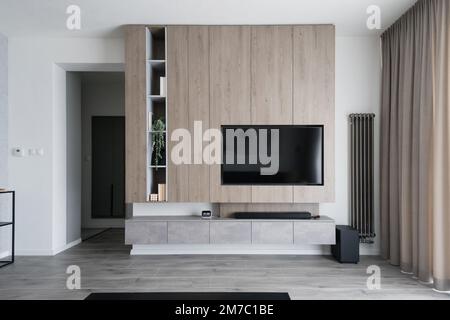 Wohnzimmerwand und eingebauter Fernseher in einem modernen Apartment Stockfoto