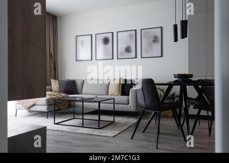 Wohnzimmer mit Sofa und Esstisch im modernen Apartment Stockfoto