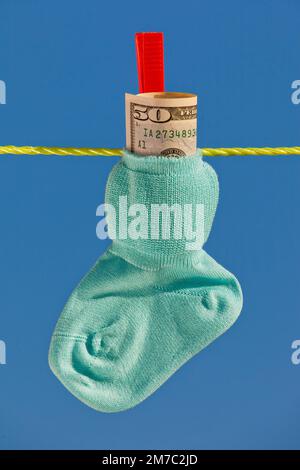 Babysocken mit Dollarscheinen auf der Wäscheleine, USA Stockfoto