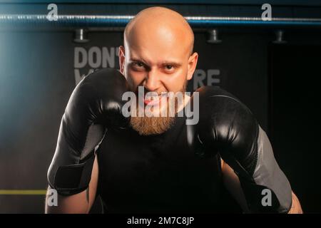Kahlköpfige Männer in Boxhandschuhen Boxständer starren wütend in die Kamera auf den Gegner Stockfoto