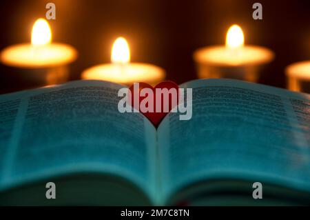 Rote Herzform auf der Heiligen Bibel mit anpassbarem Platz für Text oder Ideen. Speicherplatz kopieren. Stockfoto