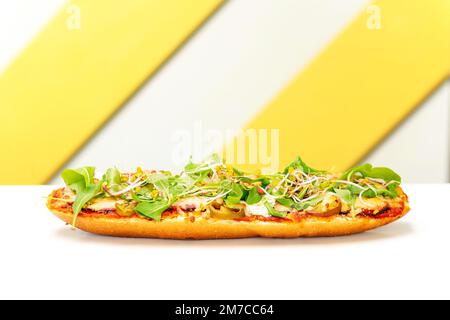 Baguette mit Tomatensoße, Fleisch, Jalapeno und Rucola, gebacken mit Käse. Beliebtes Street Fast Food Stockfoto