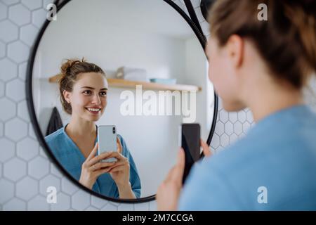 Junge Frau macht Selfie im Badezimmer. Stockfoto
