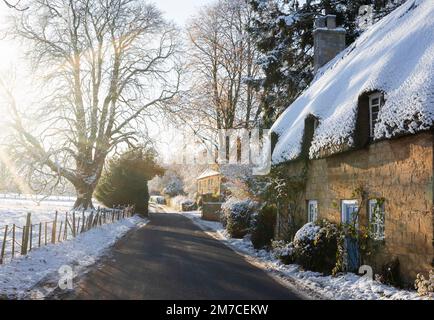 Eine strohgedeckte Hütte im Schnee im Cotswold Dorf Broadway, Worcestershire, Großbritannien Stockfoto