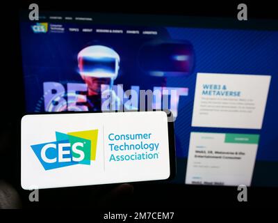 Person, die ein Mobiltelefon mit dem Logo der US Consumer Technology Association (CTA) auf dem Bildschirm vor der Unternehmenswebseite hält. Konzentrieren Sie sich auf das Display des Telefons. Stockfoto
