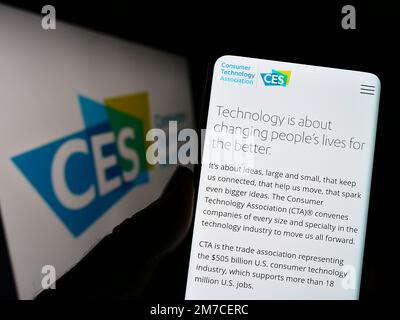 Person, die ein Mobiltelefon mit einer Webseite der US Consumer Technology Association (CTA) auf dem Bildschirm vor dem Logo hält. Konzentrieren Sie sich auf die Mitte des Telefondisplays. Stockfoto